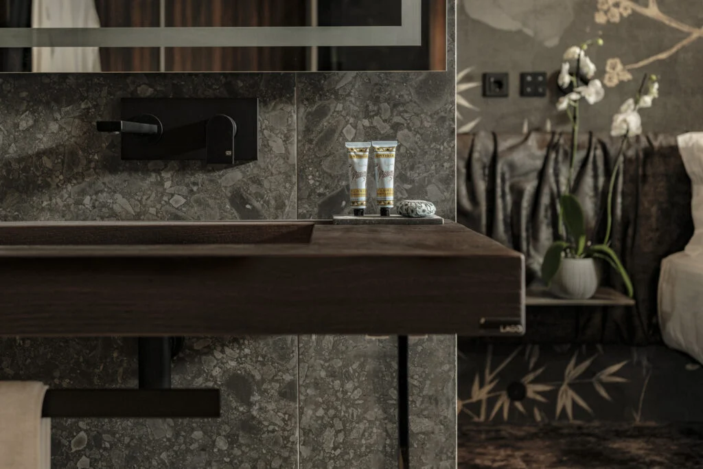 Modern bathroom vanity with dark sink and toiletries - Fitch Hotel Modern bathroom vanity with dark sink and toiletries - Fitch Hotel